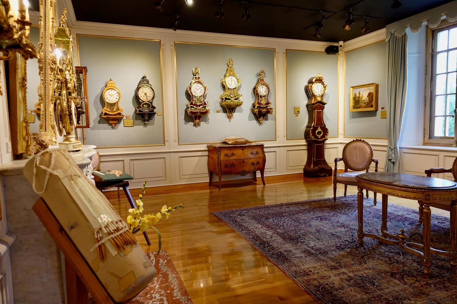 Painel de relógios de coleção expostos em vitrine de museu de relojoaria